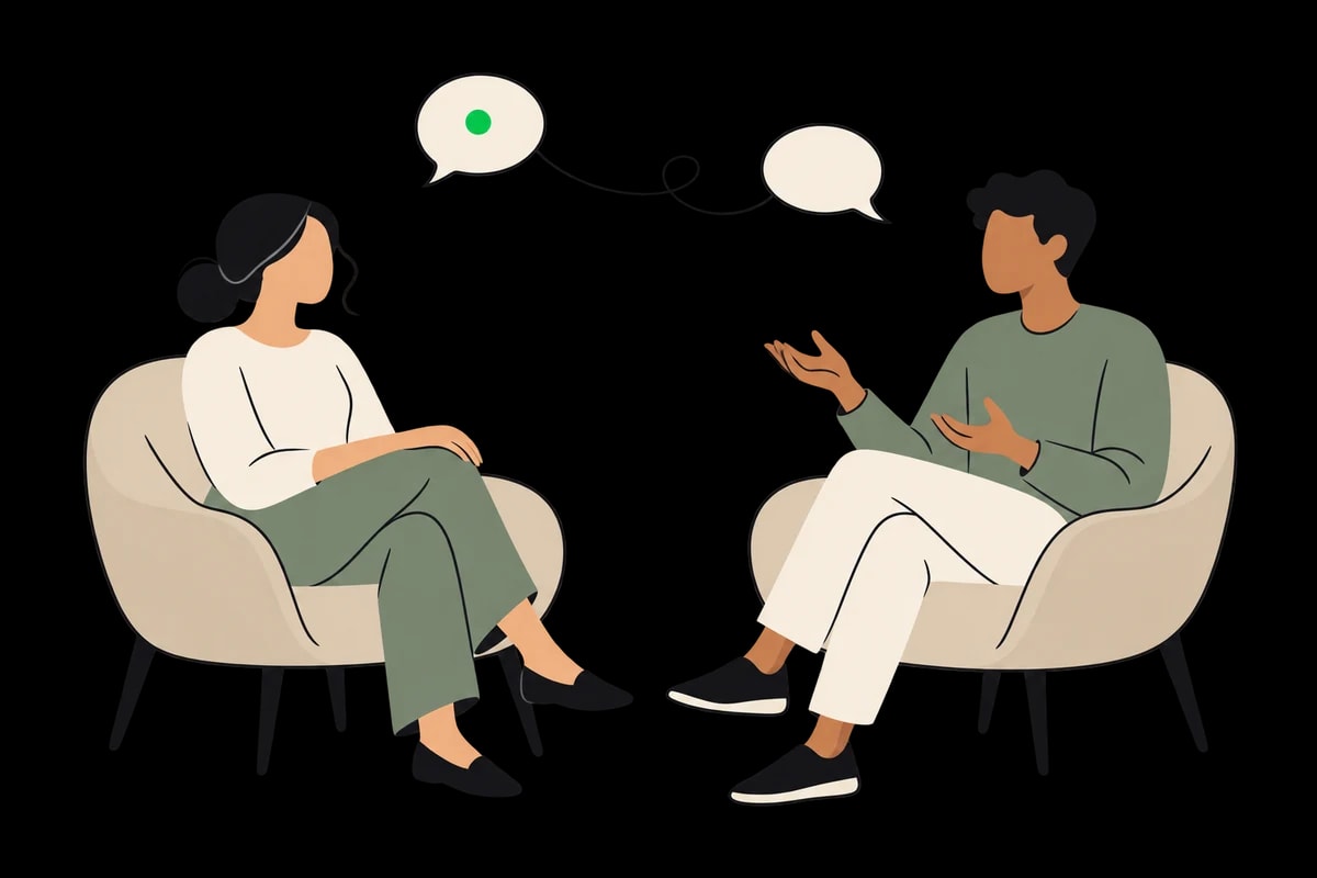 Two people sitting in armchairs, sharing a supportive conversation.